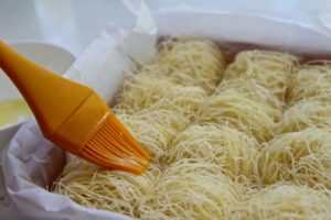 brushing butter onto Kadaif nests